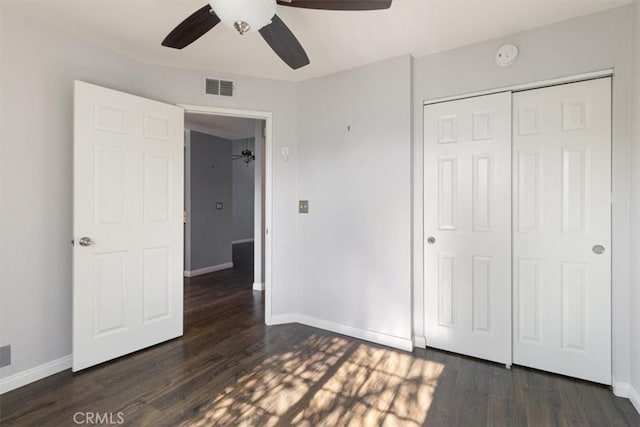 unfurnished bedroom with dark wood-type flooring, ceiling fan, and a closet