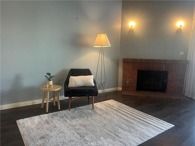 living area with a fireplace and dark hardwood / wood-style flooring