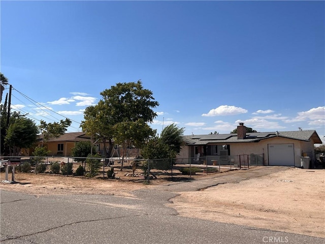 view of front of property with a garage and solar panels