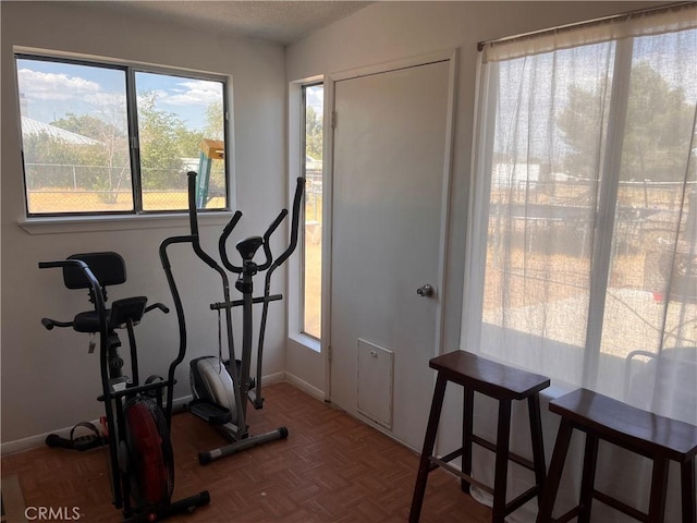 exercise room featuring parquet flooring