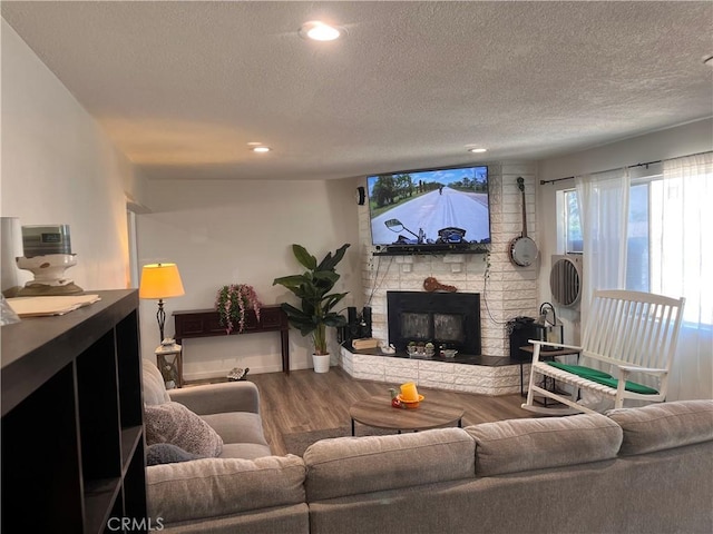 living room featuring a fireplace, hardwood / wood-style floors, and a textured ceiling