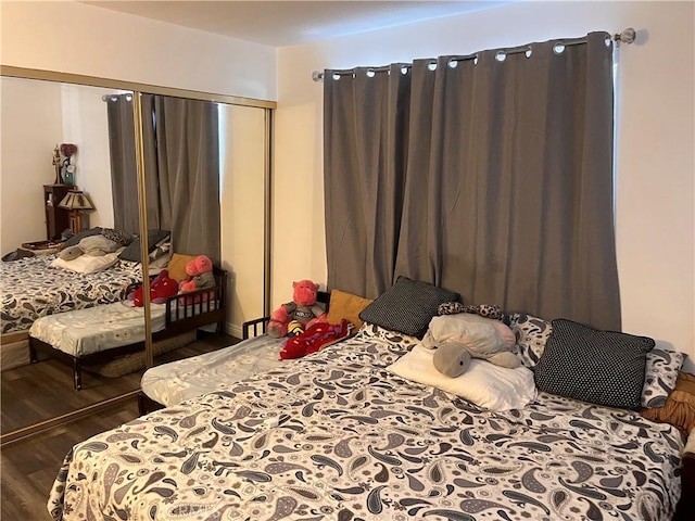 bedroom with dark hardwood / wood-style flooring and a closet