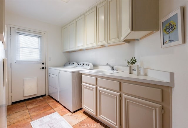 washroom featuring washing machine and dryer, sink, and cabinets