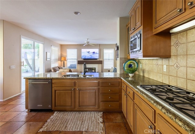 kitchen with sink, ceiling fan, tasteful backsplash, kitchen peninsula, and stainless steel appliances