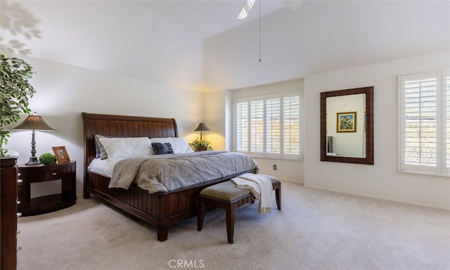 bedroom with a ceiling fan, light carpet, and lofted ceiling