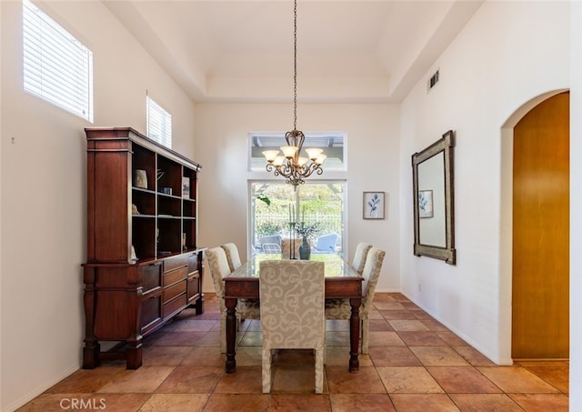 dining area featuring a chandelier, a tray ceiling, and a healthy amount of sunlight