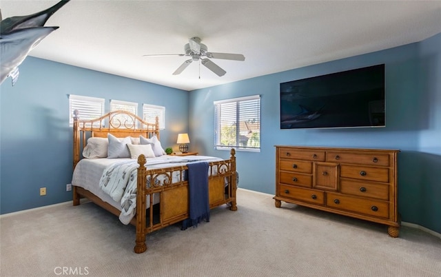 carpeted bedroom featuring baseboards and a ceiling fan