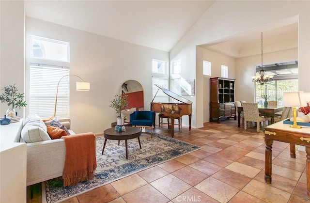 living room featuring a chandelier, high vaulted ceiling, and a healthy amount of sunlight