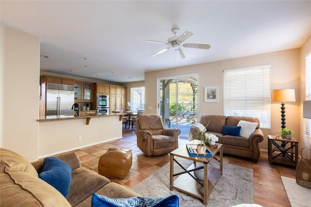 living room featuring light tile patterned floors, ceiling fan, and sink