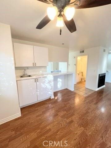 kitchen with ceiling fan, sink, white cabinets, and light hardwood / wood-style floors