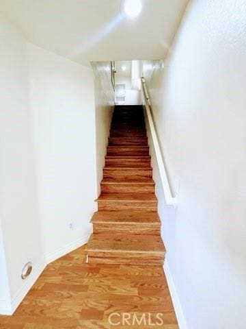 staircase with wood finished floors and baseboards