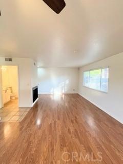 43409 30th St W Unit 1, Lancaster, CA 93536 - unfurnished living room with a fireplace, visible vents, and wood finished floors