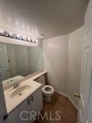 43409 30th St W Unit 1, Lancaster, CA 93536 - bathroom with tile patterned floors, toilet, baseboards, and vanity