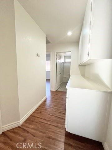 corridor with dark hardwood / wood-style flooring