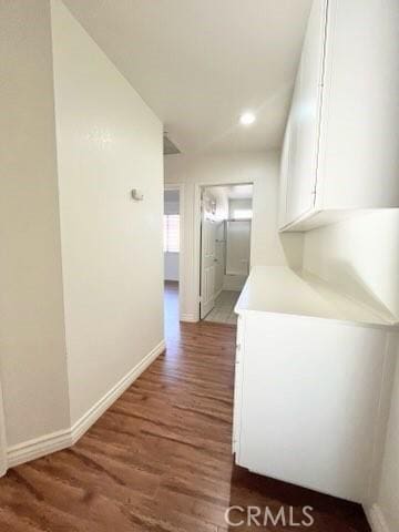 corridor with recessed lighting, wood finished floors, and baseboards