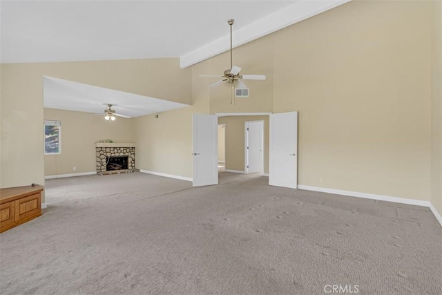 unfurnished living room featuring ceiling fan, beam ceiling, a fireplace, and carpet flooring