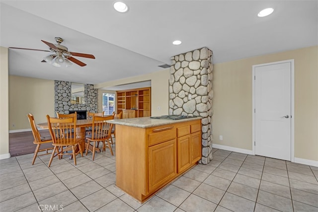 kitchen featuring stainless steel gas stovetop, ceiling fan, and kitchen peninsula