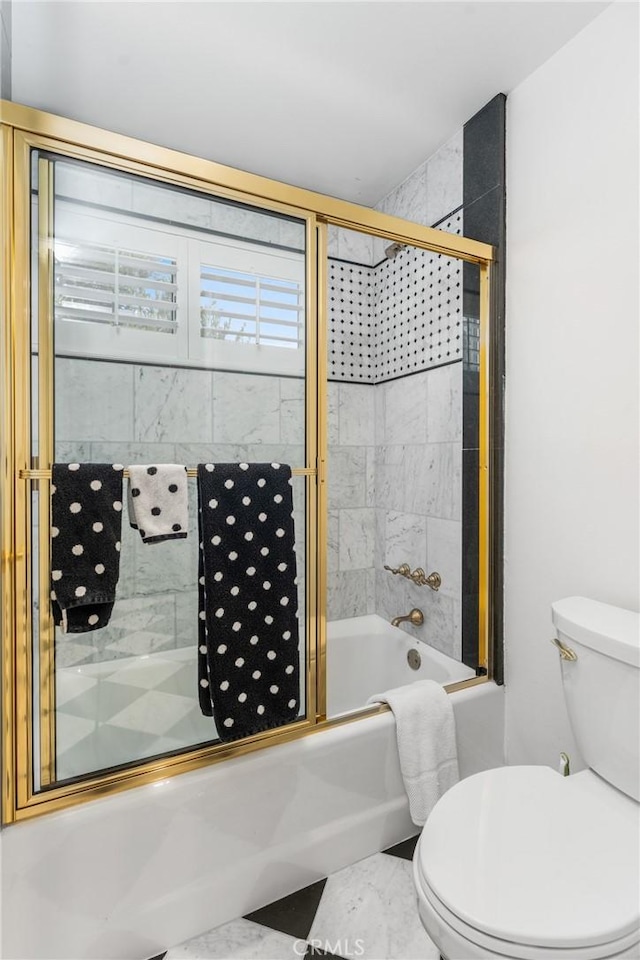 bathroom with enclosed tub / shower combo and toilet