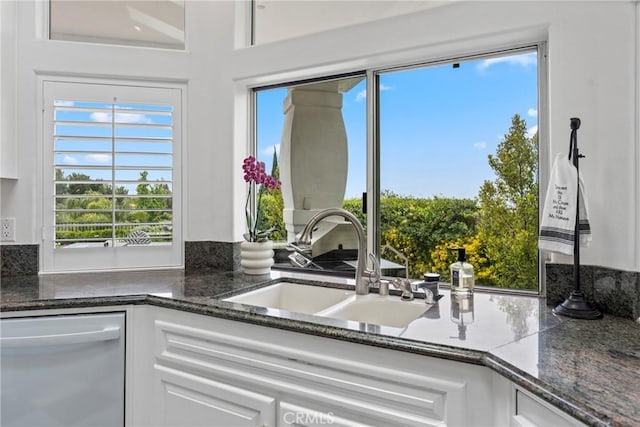 kitchen with plenty of natural light, dishwasher, sink, and white cabinets