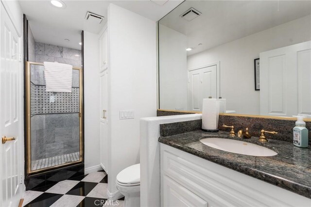 bathroom featuring vanity, toilet, and walk in shower