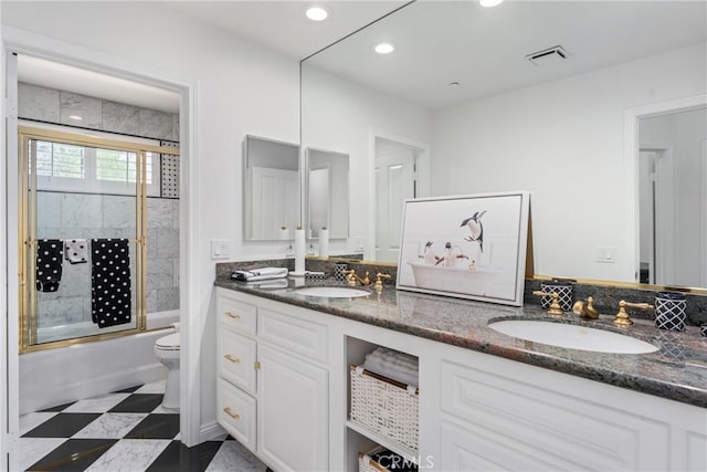 full bathroom with enclosed tub / shower combo, vanity, and toilet