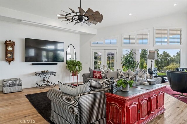 living room with light hardwood / wood-style floors, french doors, and ceiling fan