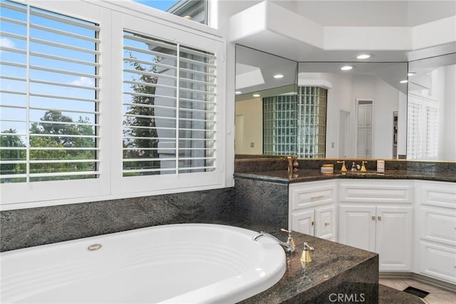 bathroom featuring vanity, a wealth of natural light, and a bathing tub