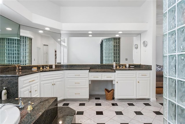 bathroom featuring a high ceiling and vanity