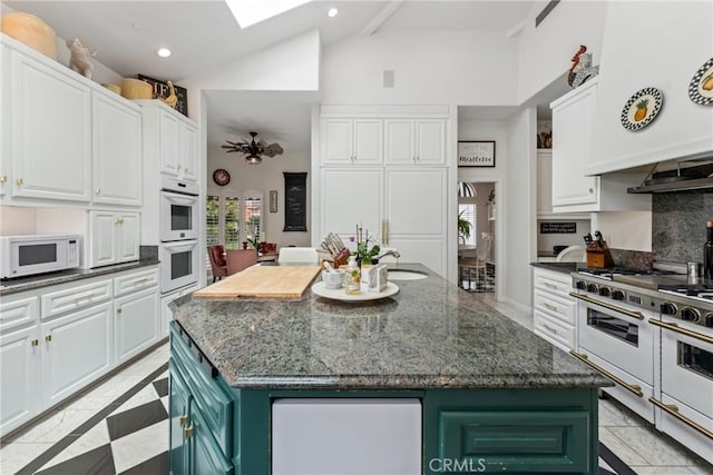 kitchen featuring white appliances, an island with sink, and white cabinets