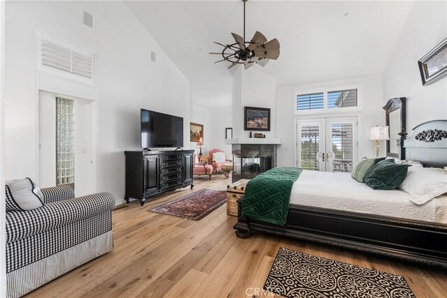 bedroom featuring french doors, high vaulted ceiling, ceiling fan, access to exterior, and light hardwood / wood-style floors