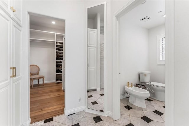 bathroom with a bidet, tile patterned flooring, and toilet