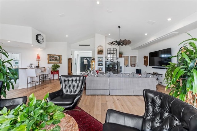 living room with ceiling fan, lofted ceiling, and light hardwood / wood-style floors