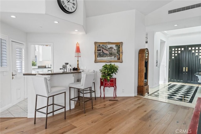 entrance foyer featuring vaulted ceiling and light wood-type flooring