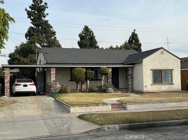 ranch-style home featuring a carport and a front yard