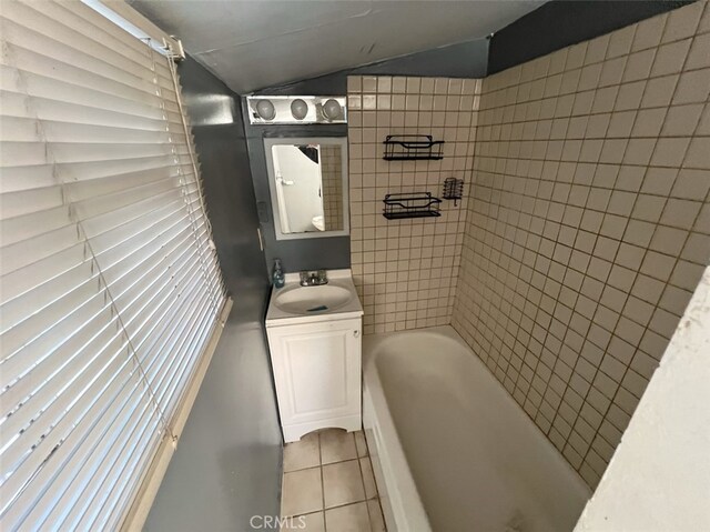 bathroom with tile patterned floors, vanity, and lofted ceiling