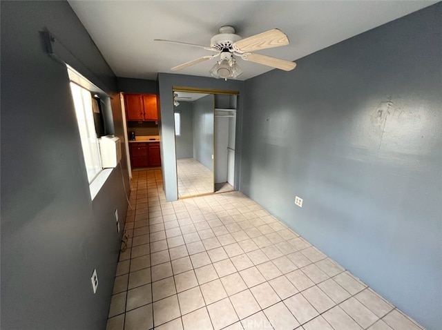 spare room with ceiling fan and light tile patterned flooring