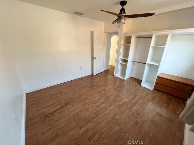 unfurnished bedroom featuring hardwood / wood-style floors, a closet, and ceiling fan