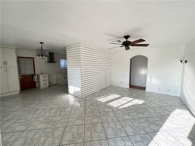 unfurnished living room featuring ceiling fan with notable chandelier