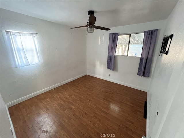 unfurnished room with ceiling fan and dark hardwood / wood-style flooring