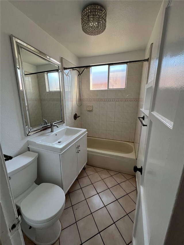 full bathroom featuring tile patterned flooring, vanity, tiled shower / bath combo, and toilet