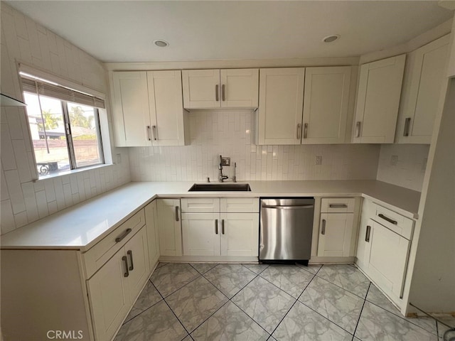 kitchen featuring white cabinets, dishwasher, decorative backsplash, and sink