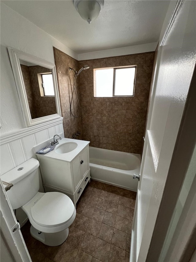 full bathroom with vanity, tiled shower / bath, and toilet