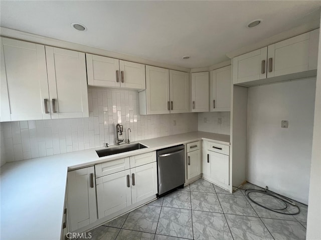 kitchen featuring backsplash, dishwasher, white cabinetry, and sink