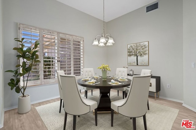 dining room with plenty of natural light, light wood-type flooring, and a chandelier