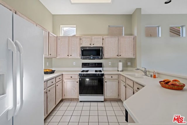 kitchen with light brown cabinetry, light tile patterned floors, and white appliances