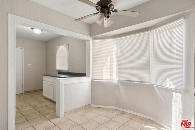 kitchen with ceiling fan, white cabinetry, and light tile patterned floors