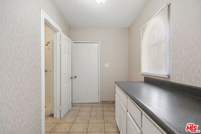 kitchen featuring white cabinets and light tile patterned flooring