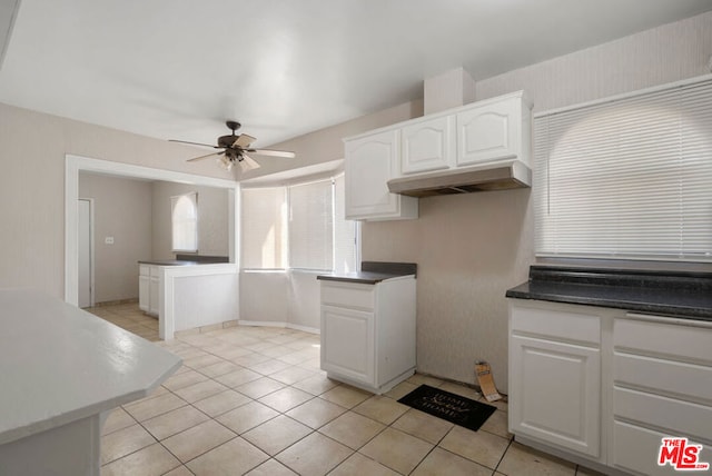 kitchen with ceiling fan, light tile patterned flooring, and white cabinetry