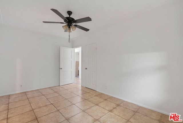 unfurnished room with ceiling fan and light tile patterned floors