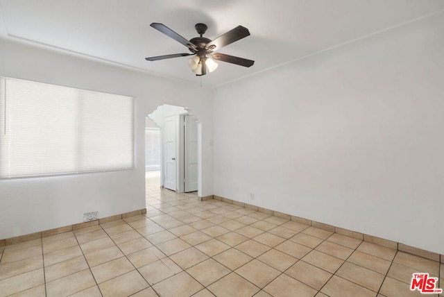 tiled spare room featuring ceiling fan